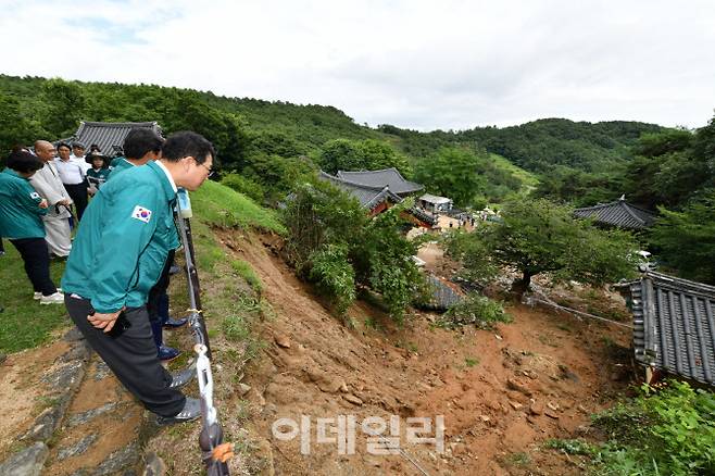 최응천 국가유산청장이 10일 오후 충남 부여군 사찰 대조사를 방문해 호우로 인한 산사태로 내부 건축물인 수각이 파손된 피해 현장을 관계자들과 긴급점검하고 있다. (사진=국가유산청)