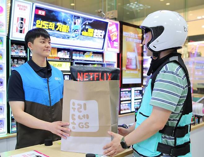 GS25의 퀵커머스 주문 상품을 전문 배달원이 전달받고 있다.ⓒGS리테일