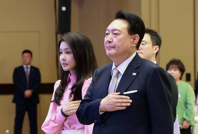 윤석열 대통령과 김건희 여사가 8일(현지시간) 미국 하와이 호놀룰루 쉐라톤 와이키키 호텔에서 열린 동포간담회에 참석해 국기에 경례하고 있다. 연합뉴스