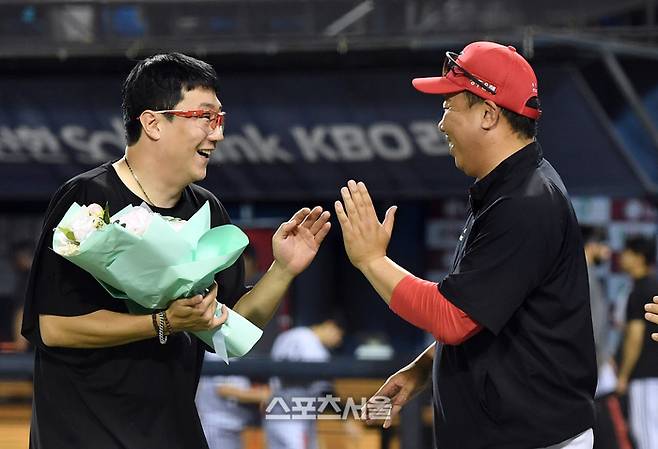 KIA 선발투수 양현종(왼쪽)이 10일 잠실구장에서 열린 2024 KBO리그 LG와 경기에 등판해 선발 400경기 출전 기록을 세운 뒤 이범호 감독이 건네는 축하 꽃다발을 받고 있다. 2024. 7. 10.  잠실 | 박진업 기자 upandup@sportsseoul.com