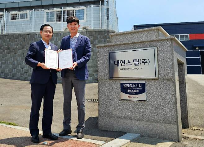 BNK경남은행 이상봉 부행장(사진 왼쪽)이 대연스틸㈜ 이정대 대표에게 유망중소기업 인증서를 전달하고 있다. BNK경남은행 제공