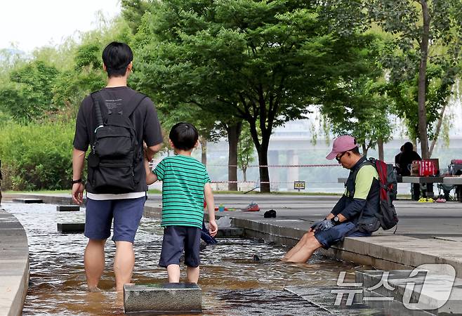 서울 여의도 한강공원을 찾은 시민들이 더위를 식히고 있다. 2024.7.7/뉴스1 ⓒ News1 장수영 기자