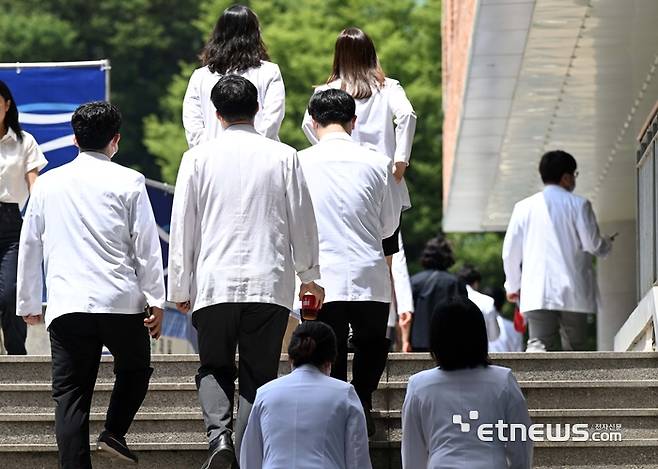 서울대 의대 산하 서울대병원·분당서울대병원·보라매병원·서울대병원강남센터 등 4개 병원 교수들이 무기한 휴진에 돌입했다. 17일 서울 종로구 서울대학교 의과대학에서 열린 '서울대학교병원 교수 휴진 선포 기자회견'이 끝난 후 의료진이 퇴장하고 있다. 김민수기자 mskim@etnews.com