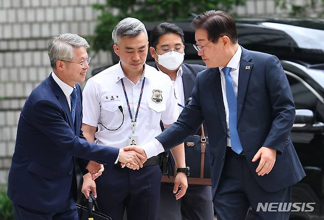 [서울=뉴시스] 김근수 기자 = 이재명(오른쪽) 전 더불어민주당 대표가 12일 서울 서초구 서울중앙지방법원에서 열린 '故김문기·백현동 허위 발언 공직선거법 위반 혐의' 관련 26차 공판에 출석에 앞서 민형배 더불어민주당 의원과 인사를 나누고 있다. 2024.07.12. ks@newsis.com