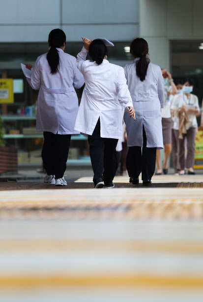 장맛비가 내린 8일 서울 시내 한 병원에서 의료진이 서류 등으로 머리를 가린 채 이동하고 있다. 기사와 관계없음(사진=연합뉴스)