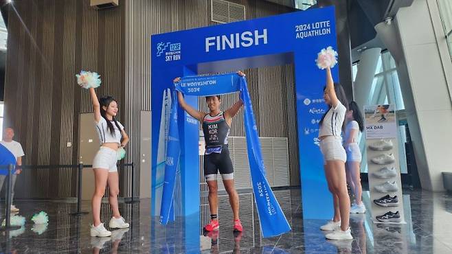 2024 롯데 아쿠아슬론 남자 일반인 부문에서 우승을 차지한 김완혁씨가 결승 테이프를 끊은 뒤 세레모니를 펼치고 있다.  /조성필 기자 @gatozz