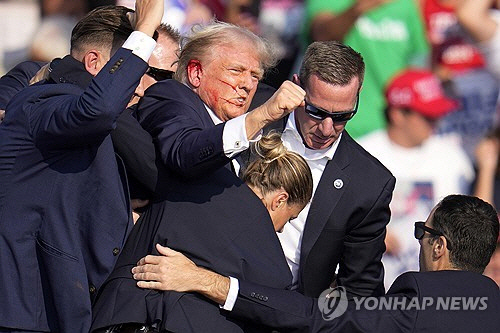 미국 공화당의 대선 후보인 도널드 트럼프 전 대통령이 13일(현지시간) 펜실베이니아주 버틀러에서 유세 도중에 총격 사건이 발생하자 경호 요원들의 부축을 받으며 무대에서 내려가고 있다.  [버틀러[美펜실베이니아주] AP=연합뉴스]