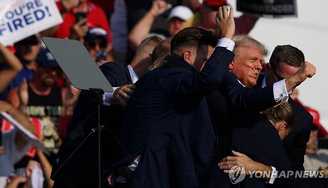 US-DONALD-TRUMP-HOLDS-A-CAMPAIGN-RALLY-IN-BUTLER,-PENNSYLVANIA BUTLER, PENNSYLVANIA - JULY 13: Secret Service agents surround Republican presidential candidate former President Donald Trump onstage after he was injured at a rally on July 13, 2024 in Butler, Pennsylvania. According to Butler County District Attorney Richard Goldinger, the suspected gunman is dead after injuring former President Trump, killing one audience member and injuring at least one other.   Jeff Swensen/Getty Images/AFP (Photo by JEFF SWENSEN / GETTY IMAGES NORTH AMERICA / Getty Images via AFP)