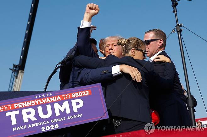 총격 직후 유세장을 떠나면서 지지자들에게 주먹 들어보이는 트럼프 전 미국 대통령 [AFP=연합뉴스]