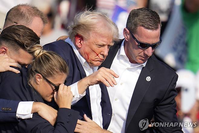 총격 당한 트럼프 전 미국 대통령을 대피시키는 경호요원들 [버틀러[미 펜실베이니아주] AP=연합뉴스)