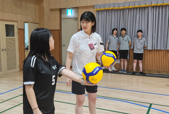 여자프로배구 흥국생명에서 아웃사이드 히터로 뛰고 있는 김다은(오른쪽)이 지난 12일 인천 갈산중학교 체육관에서 열린 '일일 유소년 배구교실'에 강사로 참여해 학생들을 대상으로 서브에 대해 알려주고 있다. [사진=흥국생명 핑크스파이더스 배구단]