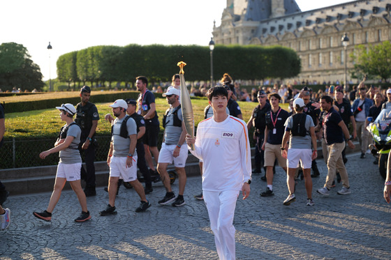 Jin carries the Olympic torch in Paris on July 14. [BIGHIT MUSIC]