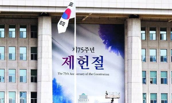 지난해 7월 서울 여의도 국회 본청에 제75주년 제헌절을 알리는 초대형 현수막이 내걸리고 있다. 연합뉴스