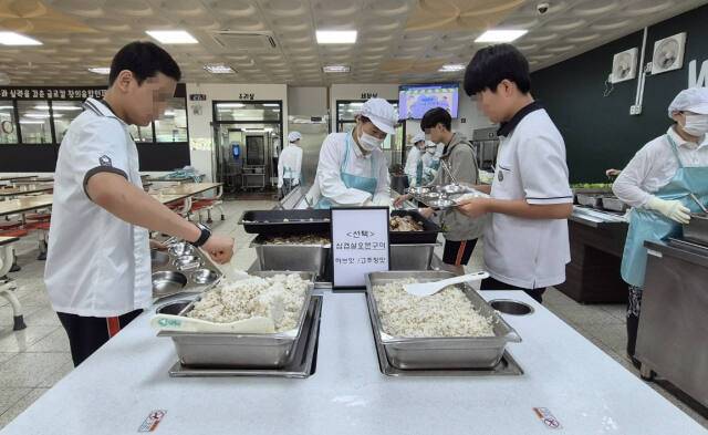 자율선택급식 실천학교로 선정된 화성 동탄중에서 17일 학생들이 자율배식으로 밥을 식판에 담고 있다. 김한울기자