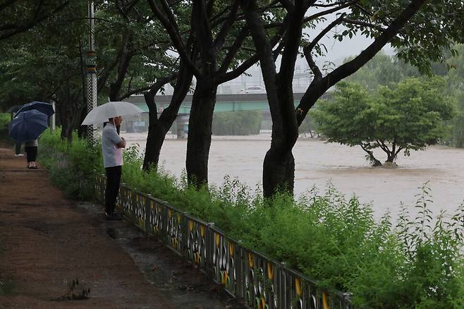 18일 오전 시민들이 오산근린공원에서 물이 불어난 오산천을 바라보고 있다. 김영원 기자