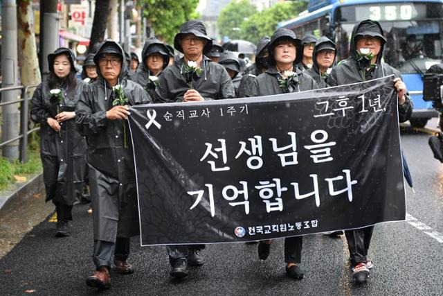 전국교직원노동조합 조합원들과 시민들이 서이초 교사 순직 1주기인 18일 서울 서초구 서이초등학교 앞에서 국화꽃을 들고 행진하고 있다. 신용주 인턴기자