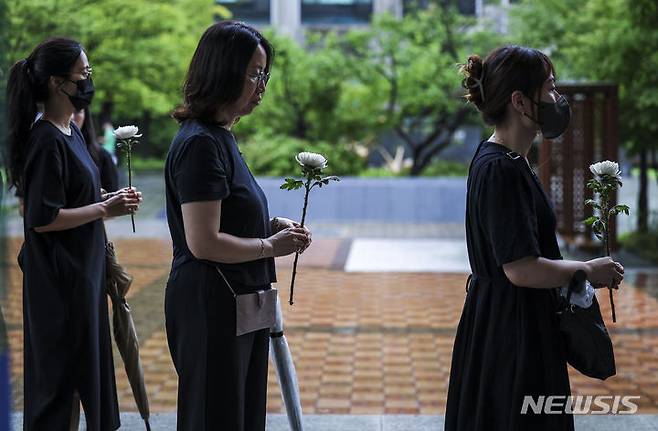 [서울=뉴시스] 정병혁 기자 = 서이초 순직교사 1주기인 18일 서울 서초구 서울교육대학교에서 열린 교사유가족협의회, 초등교사노동조합 2024 순직교사 추모행사를 찾은 교사 및 시민들이 헌화를 하고있다.  2024.07.18. jhope@newsis.com