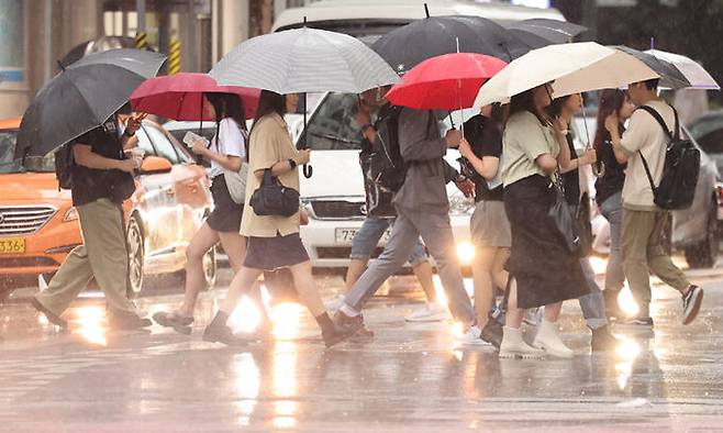 중부지방에 호우특보가 내려진 18일 서울 강남역 인근에서 우산을 쓴 시민들이 발걸음을 재촉하고 있다. 뉴스1