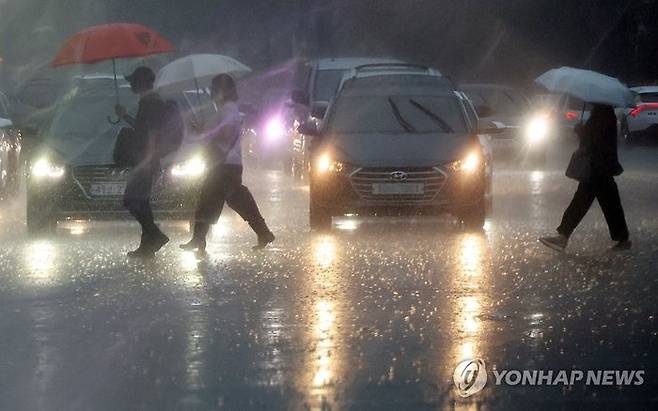 지난 17일 오전 서울 시내에서 우산을 쓴 시민들이 길을 건너고 있다.ⓒ연합뉴스