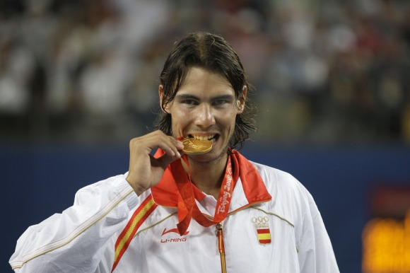 Tennis Preview Olympics - FILE - Rafael Nadal of Spain bites his gold medal for the photographers after beating Fernando Gonzalez of Chile during their Gold medal singles tennis at the Beijing 2008 Olympics in Beijing, Sunday, Aug. 17, 2008. The tennis competition at the Paris Olympics could be where past gold medalists Rafael Nadal and Andy Murray bid adieu to the sport.(AP Photo/Elise Amendola, File) FILE PHOTO;