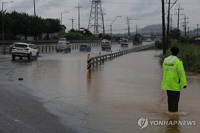 폭우에 침수된 도로 (파주=연합뉴스) 임병식 기자 = 18일 오전 경기도 파주시 월롱역 인근 도로가 물에 잠겨 경찰이 현장을 통제하고 있다. 2024.7.18 andphotodo@yna.co.kr