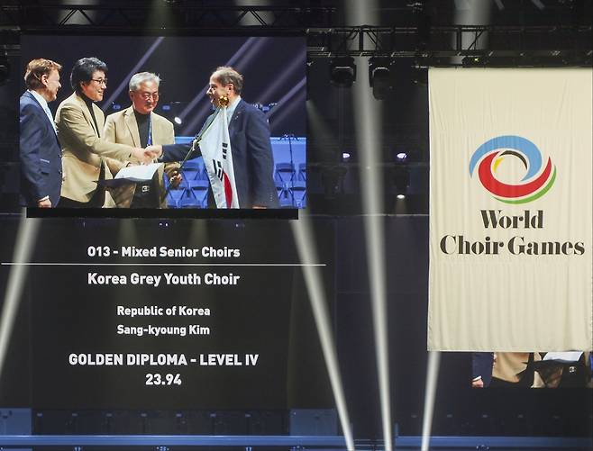 19일 '2024 세계합창경연대회'(World Choir Games) 시상식에서 윤학수 단장과 김상경 지휘자가 시니어 부문 대상을 수상하고 있다.(남자의 자격 청춘합창단 제공)