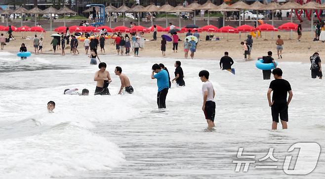 장마가 소강상태를 보이며 무더운 날씨를 보인 19일 오후 부산 수영구 광안리해수욕장을 찾은 학생 등 피서객들이 물놀이를 하며 더위를 식히고 있다. 2024.7.19/뉴스1 ⓒ News1 윤일지 기자