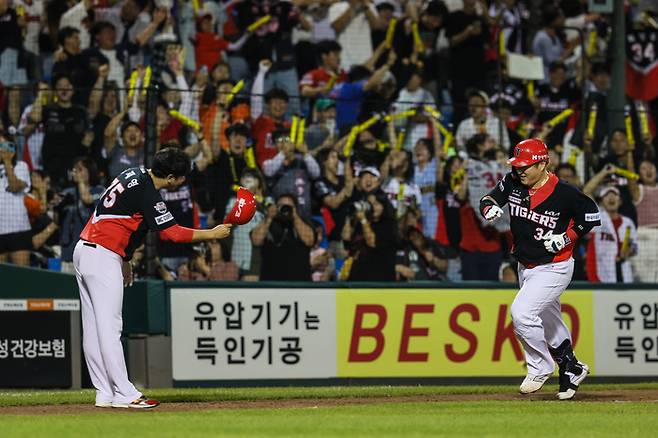 홈으로 들어오는 최형우, 원정석에서 환호하는 팬들. KIA 제공