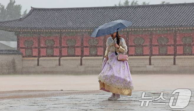 강풍을 동반한 많은 장맛비가 내린 22일 오후 서울 종로구 경복궁을 찾은 외국인 관광객들이 우산으로 비를 피하고 있다. 2024.7.22/뉴스1 ⓒ News1 장수영 기자