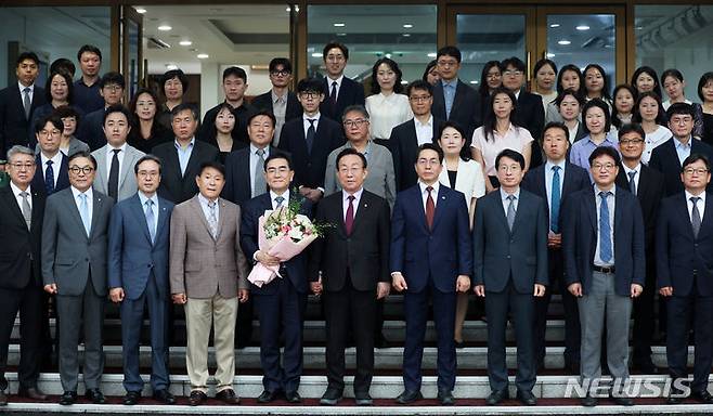 [서울=뉴시스] 이영환 기자 = 태영호(앞줄 왼쪽 다섯 번째) 신임 민주평화통일자문회의(민주평통) 사무처장이 22일 오전 서울 중구 민주평통 사무처 대회의실에서 열린 취임식을 마친 후 현관에서 김관용(앞줄 왼쪽 여섯 번째) 수석부의장 및 직원들과 기념촬영을 하고 있다. 2024.07.22. 20hwan@newsis.com