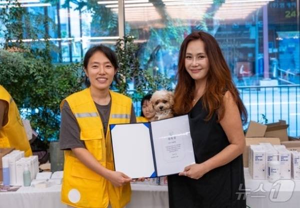 이지은 아크 기획위원장은 20일 성악가 신문희 씨에게 홍보대사 위촉장을 전달했다(아크보호소 제공). ⓒ 뉴스1