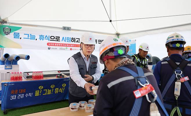 박현철 롯데건설 부회장이 천안 롯데캐슬 더 청당 현장에서 근로자들에게 팥빙수와 건강음료, 혹서기 용품 등을 건네고 있다. /롯데건설 제공