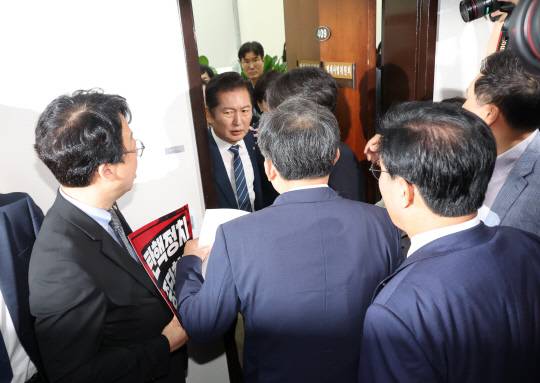 정청래 국회 법제사법위원회 위원장이 지난 19일 국민의힘 의원들의 항의를 받으며 '윤석열 대통령 탄핵소추안 발의 요청' 국민동의 청원 청문회가 열리는 회의장으로 이동하고 있다. [연합뉴스 제공]