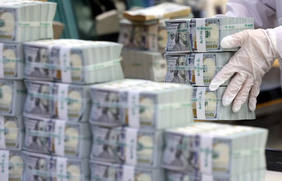 An employee arranges stacks of dollar bills at Hana Bank's Counterfeit Notes Response Center in Jung District, central Seoul, on Tuesday. [NEWS1]