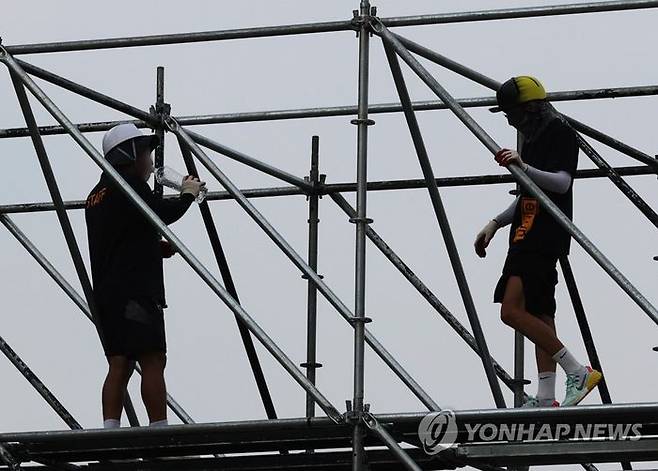 무더위 속 공사현장에서 건설노동자들이 물을 마시며 휴식을 취하고 있다.ⓒ연합뉴스