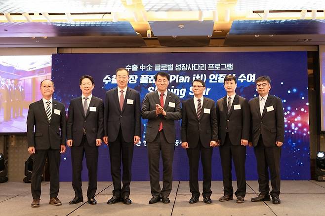 한국무역보험공사의 ‘수출성장 플래닛’ 발대식에서 장영진 사장(가운데)이 샤이닝 스타로 선정된 중소기업 대표들에게 인증서를 수여한 뒤 격려하고 있다. 한국무역보험공사 제공