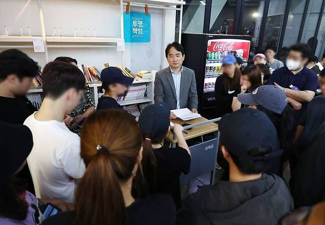 [류화현 위메프 대표이사가 25일 새벽 서울 강남구 위메프 본사에서 정산 지연 사태로 상품을 환불받으려는 고객들을 응대하고 있다. (사진=연합뉴스)]