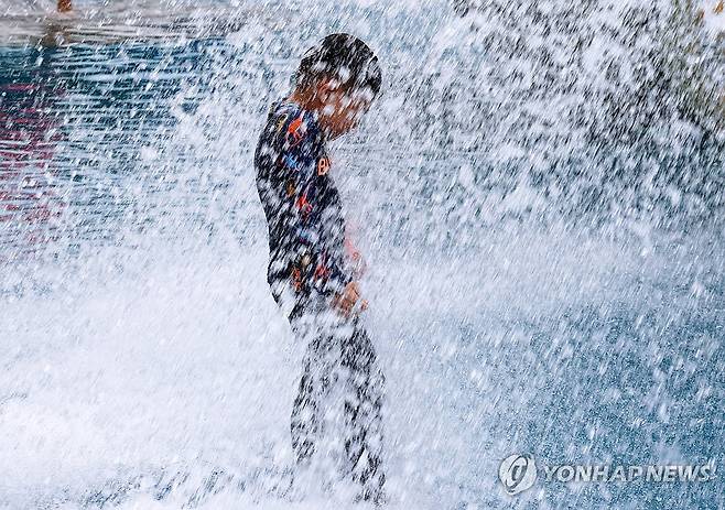 시원해요 (광주=연합뉴스) 조남수 기자 = 전국 대부분 지역에 폭염특보가 발효된 25일 오후 광주 북구 시민의숲 물놀이장에서 아이가 떨어지는 물줄기를 맞고 있다. 2024.7.25 iso64@yna.co.kr