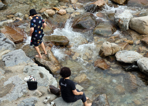 지난 25일 오후 충남 공주시 반포면 계룡산 동학사 계곡을 찾은 시민들이 계곡물에 발을 담그고 있다. (사진=연합뉴스)