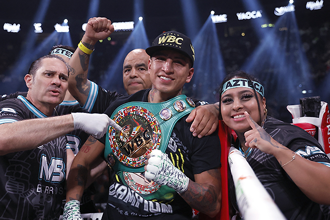 마리오 바리오스(가운데)가 2023년 9월 WBC 웰터급 잠정 타이틀매치 승리 후 챔피언 벨트를 어깨에 메고 기념 촬영을 하고 있다. 사진=Getty Images=연합뉴스 제공