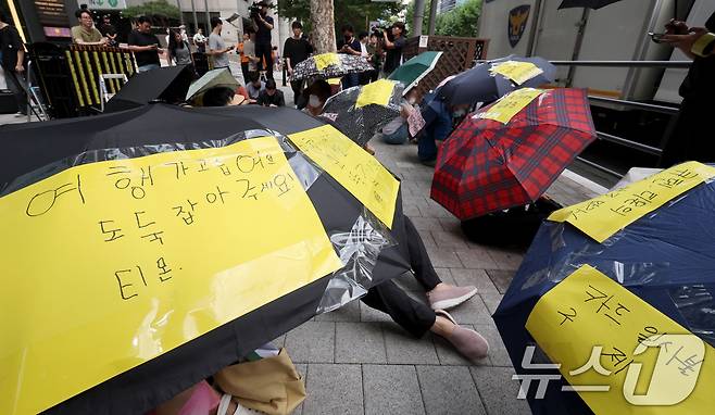 티몬과 위메프의 정산·환불 지연 사태가 지속되고 있는 28일 오후 서울 강남구 큐텐 본사 앞에서 피해자들이 사태 해결을 촉구하는 문구를 붙인 우산을 쓴 채 시위하고 있다. 2024.7.28/뉴스1 ⓒ News1 장수영 기자