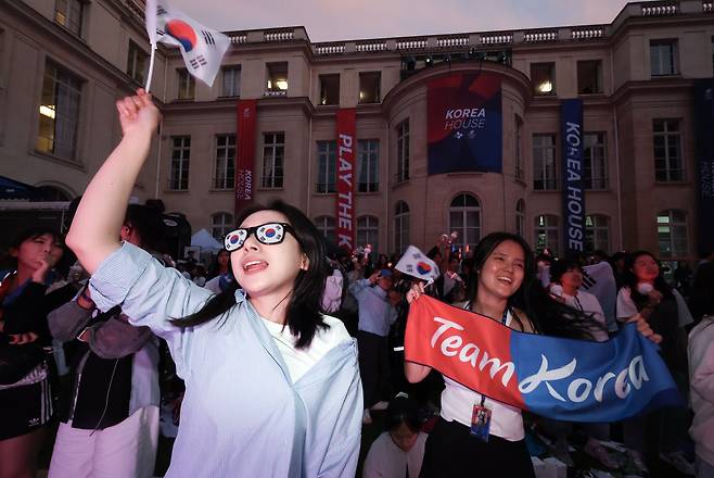 참석자들이 수영 김우민과 펜싱 오상욱의 경기를 지켜보며 응원하고 있다. 파리=김성룡 기자