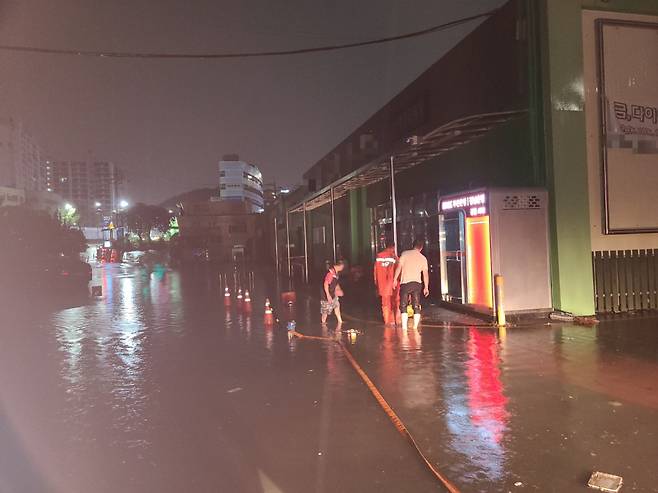 24일 새벽 호우특보가 발효된 부산 사하구의 한 상가 앞 도로가 침수돼 상가까지 물이 찼다./사진=뉴시스(부산소방재난본부 제공)