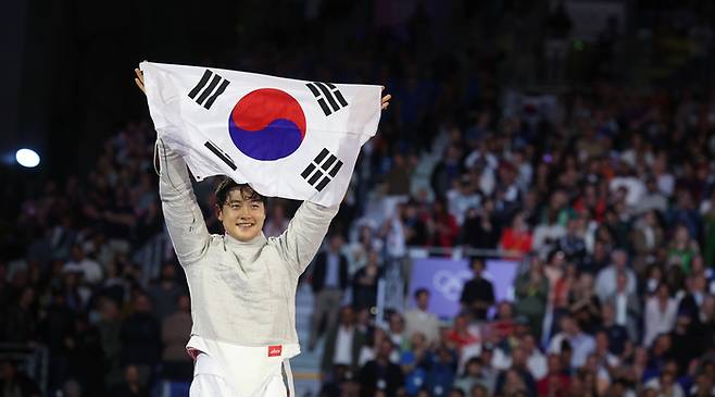오상욱이 28일(한국시간) 2024 파리 올림픽 펜싱 남자 사브르 개인전 결승에서 파레스 페르자니(튀지니)를 꺾고 우승한 뒤 태극기를 펼쳐보이고 있다. 파리|연합뉴스