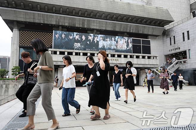 29일 오후 서울 종로구 세종문화회관 앞에서 열린 '지진 대응 훈련'에서 관계자들이 대피하고 있다. 2024.7.29/뉴스1 ⓒ News1 이승배 기자