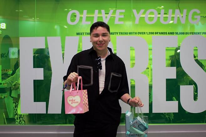 뷰티 틱톡커 카를로스 세르반테스(28) 씨가 27일(현지시간) 미국 로스앤젤레스 컨벤션센터에서 열린 케이콘 LA 2024 올리브영 부스에서 관련 제품들을 들어 포즈를 취하고 있다.