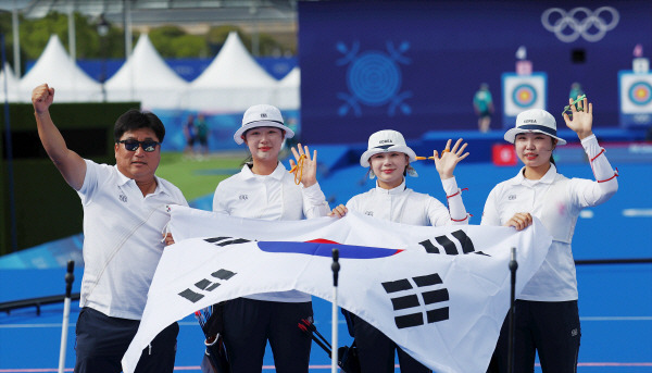 전훈영, 임시현, 남수현이 28일(현지시간) 프랑스 파리 레쟁발리드 양궁 경기장에서 열린 2024 파리올림픽 양궁 여자단체 결승전에서 중국을 이기고 우승을 확정한 뒤 태극기를 펼치고 있다. 연합뉴스