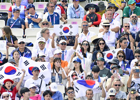 Hyundai Motor Group Executive Chair Euisun Chung, center, holds Korea's national flag, to cheer Korean archers in the women's team archery gold medal match against China at the Invalides in Paris on Sunday. [KOREA ARCHERY ASSOCIATION]