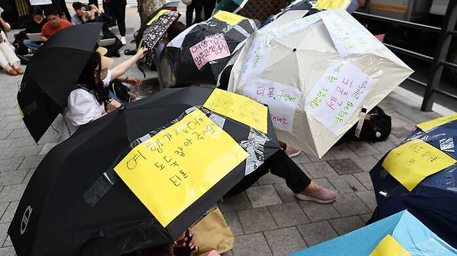 지난 28일 서울 강남구 큐텐 앞에서 빠른 환불과 대책 마련 등을 촉구하며 우산 시위하는 피해자들