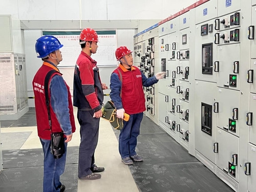 State Grid Dingxi Electric Power Company's staff performing electrical safety inspection in the power distribution room of Longxi Qizheng Medicine Co., Ltd.